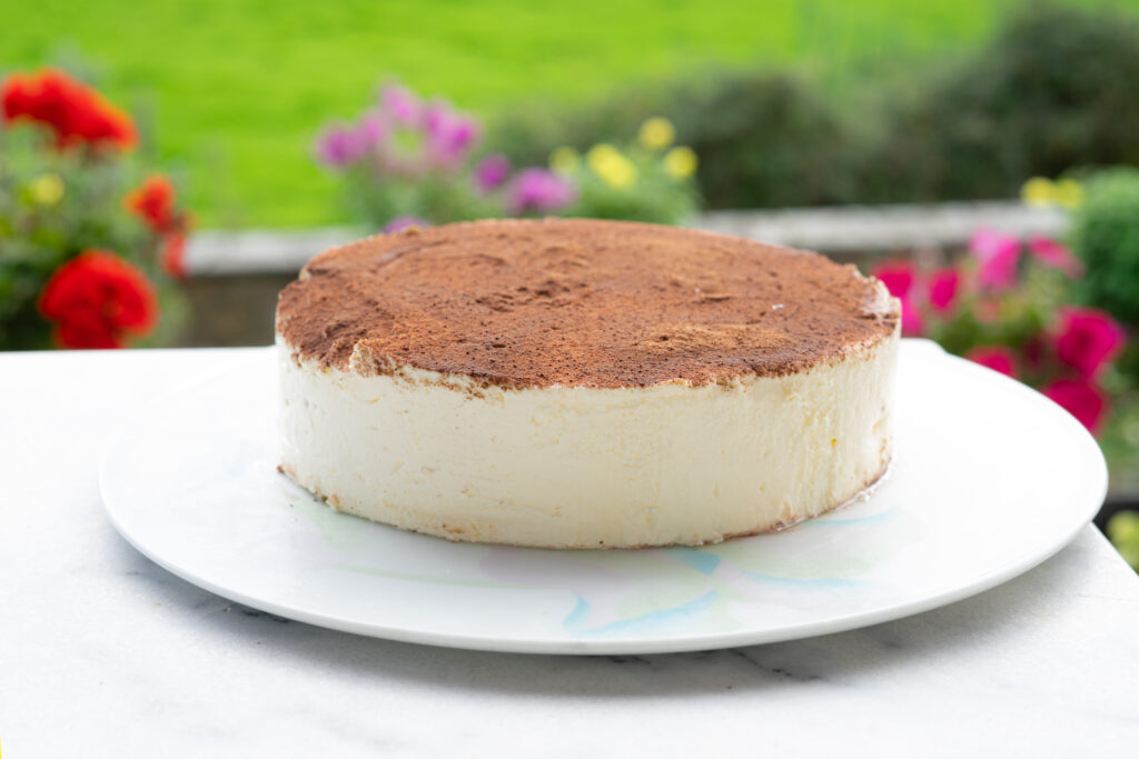 Entremet tiramisu gourmand en coupe, alternant des couches crémeuses de mascarpone et un biscuit moelleux imbibé de café, surmonté de cacao en poudre pour une finition élégante et gourmande.