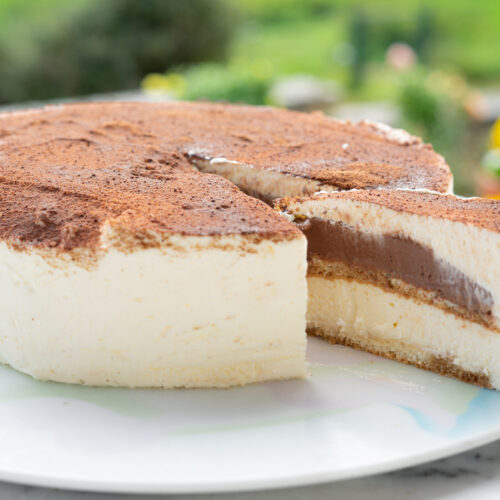 Entremet tiramisu gourmand en coupe, alternant des couches crémeuses de mascarpone et un biscuit moelleux imbibé de café, surmonté de cacao en poudre pour une finition élégante et gourmande.
