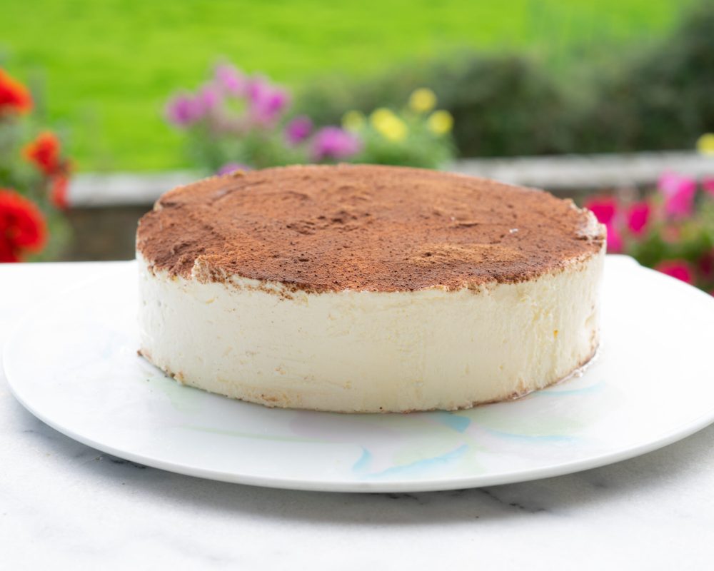 Entremet tiramisu gourmand en coupe, alternant des couches crémeuses de mascarpone et un biscuit moelleux imbibé de café, surmonté de cacao en poudre pour une finition élégante et gourmande.